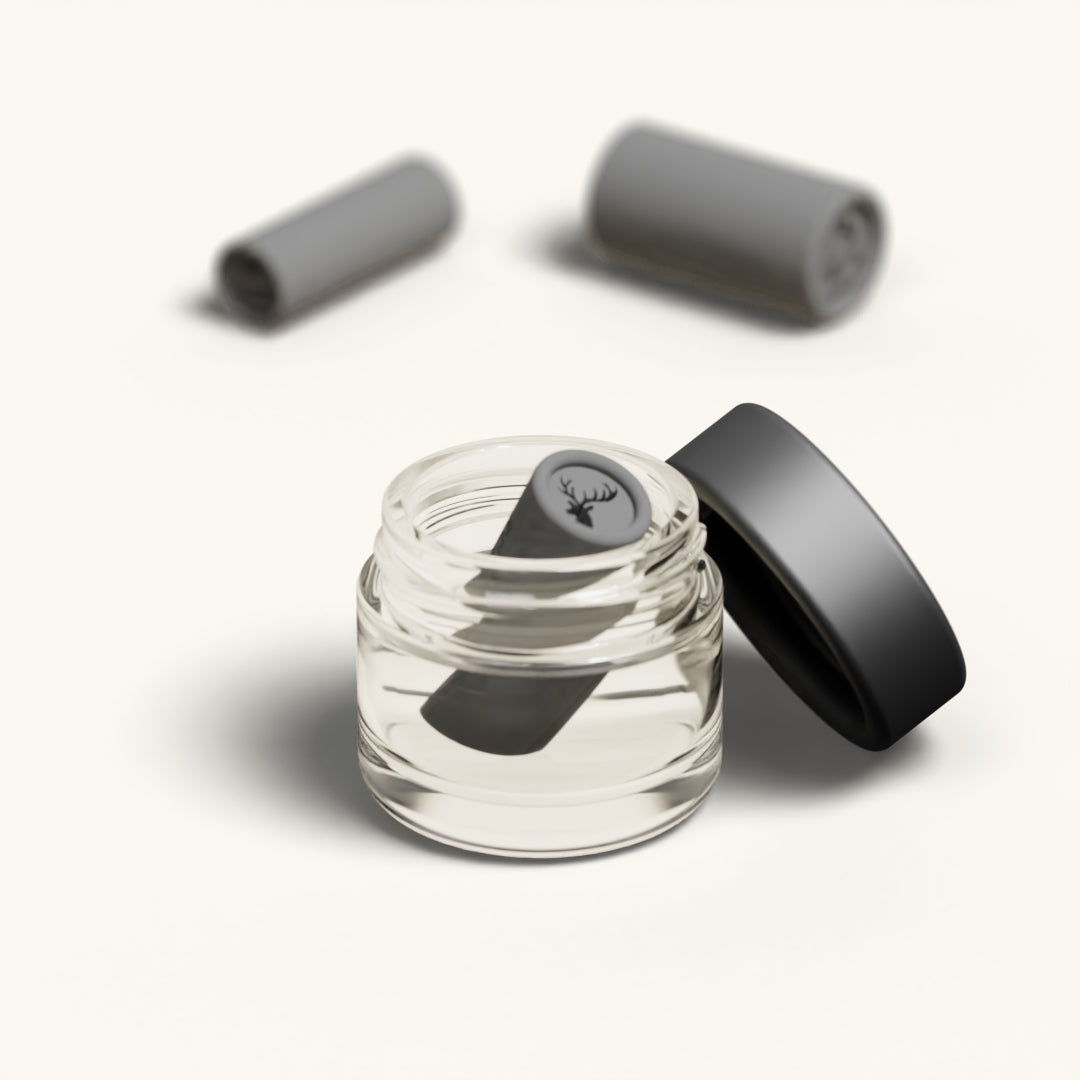 A single tip with the Stag design resting in the open glass cleaning jar