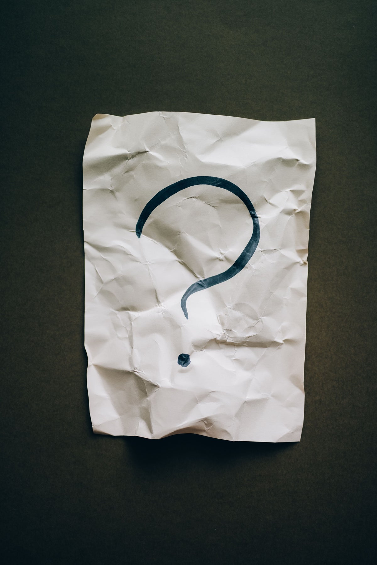 Crumpled paper with a question mark drawn on it