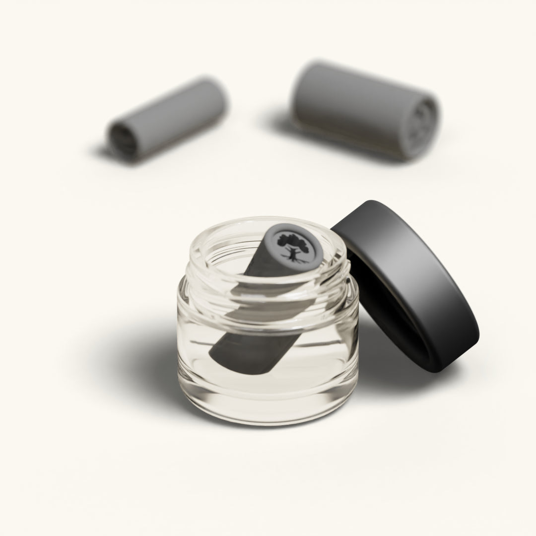 A single tip with the Tree of Life design resting in the open glass cleaning jar